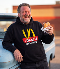 Man wearing the black Unvaxxed Hoodie at a fast-food lot