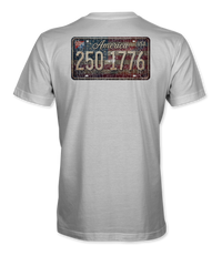 The Alex Jones Store - Back of white 'America 250 1775' tee with distressed vintage license plate graphic over American flag background