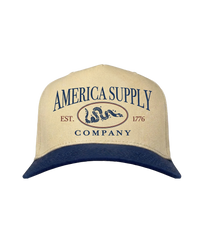 The Alex Jones Store - Tan and navy two-tone America Supply Co. 'Est. 1776' Trucker Hat with rattlesnake oval logo, front view