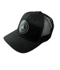 The Alex Jones Store - Three-quarter view of black trucker hat with Obedience To God circle star leather patch and mesh back