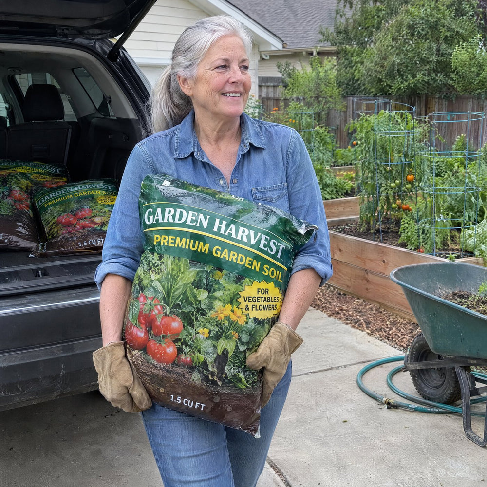 Woman in her sixties carrying a bag of garden soil